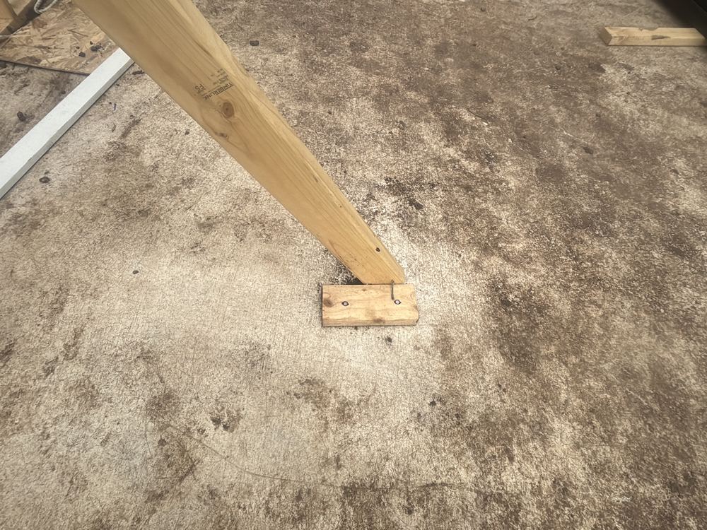 Temporary bracing blocks shot into the garage slab, risking damage to the concrete, found during a frame inspection in Beveridge