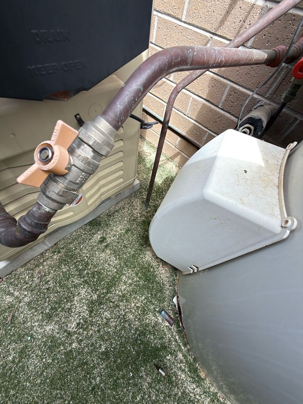 Hot water relief valve discharging right against the external wall, found during a pre-purchase building and pest inspection in Doreen